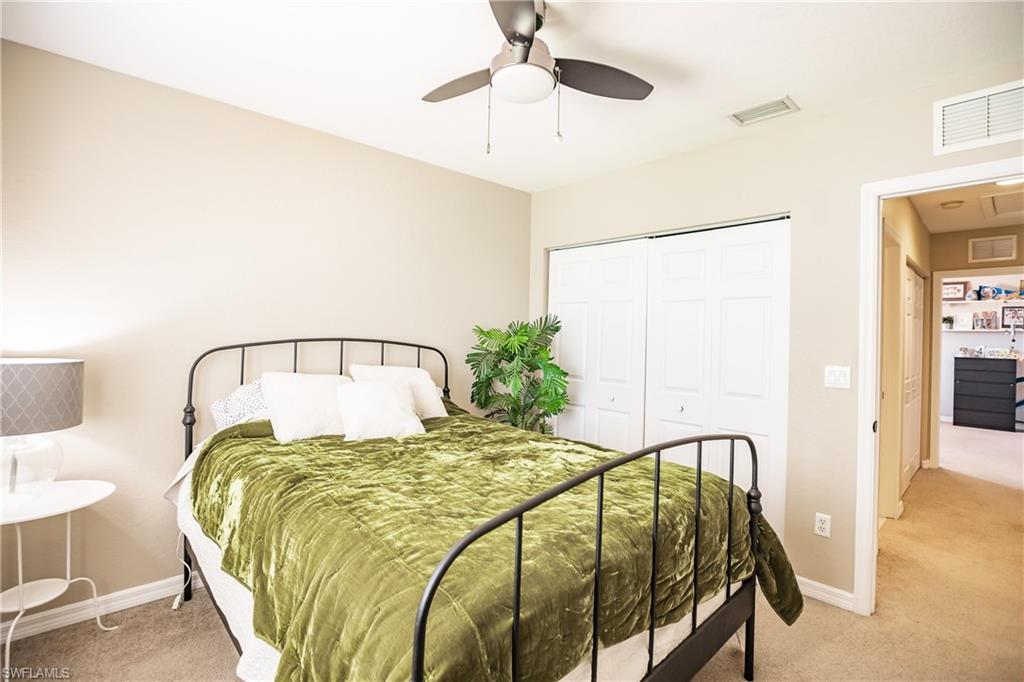 2104 Par Drive Naples, FL 34120 - Photo 22 of 26 a bed sitting in a bedroom next to a lamp