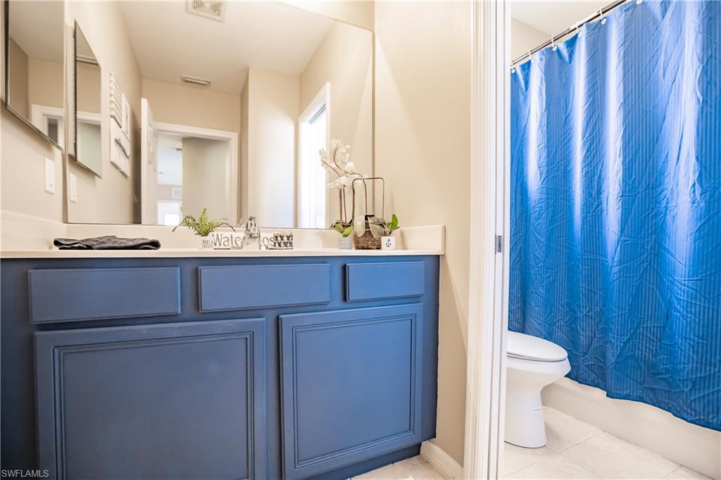 2104 Par Drive Naples, FL 34120 - Photo 23 of 26 a bathroom with a sink a toilet and shower curtain