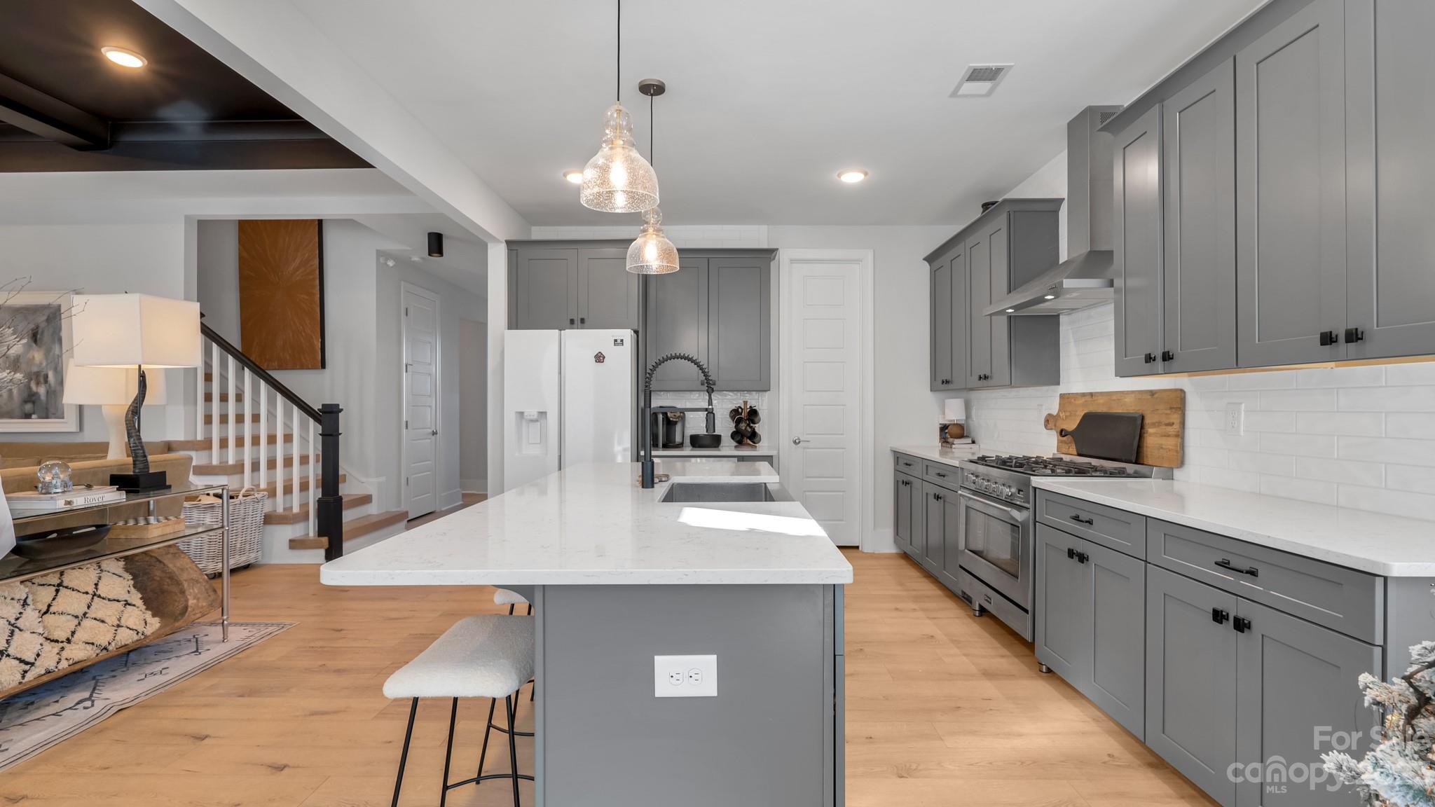 5351 Fewell Road Clover, SC 29710 - Photo 8 of 27 a kitchen with stainless steel appliances kitchen island granite countertop a refrigerator a stove top oven a sink dishwasher and white cabinets with wooden floor