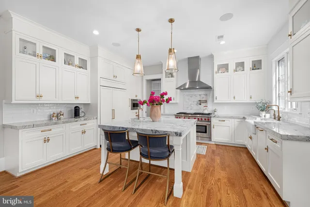 a kitchen with stainless steel appliances granite countertop a white cabinets and wooden floors