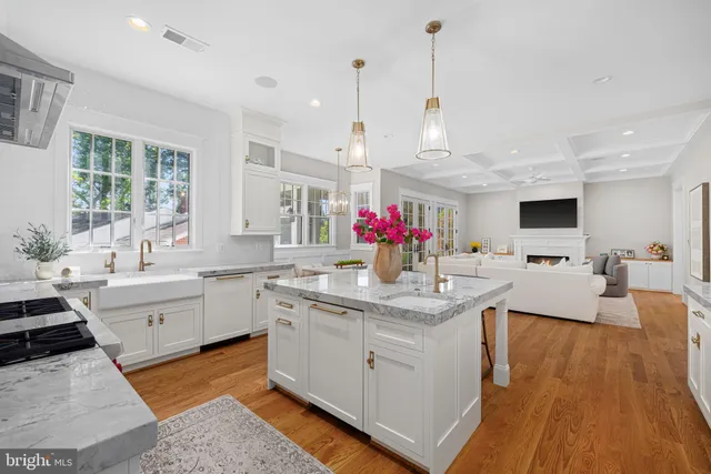 a large kitchen with kitchen island a sink dishwasher a dining table and chairs with wooden floor