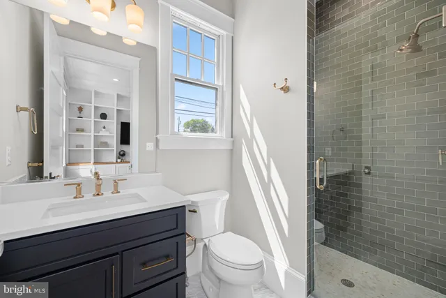 a bathroom with a sink a toilet a mirror and shower