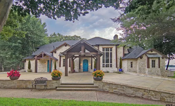 a front view of a house with a garden and tree