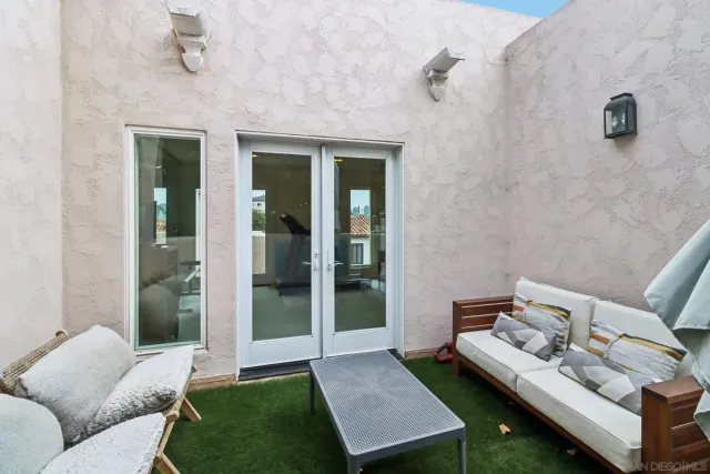 a living room with furniture a flat screen tv and a floor to ceiling window
