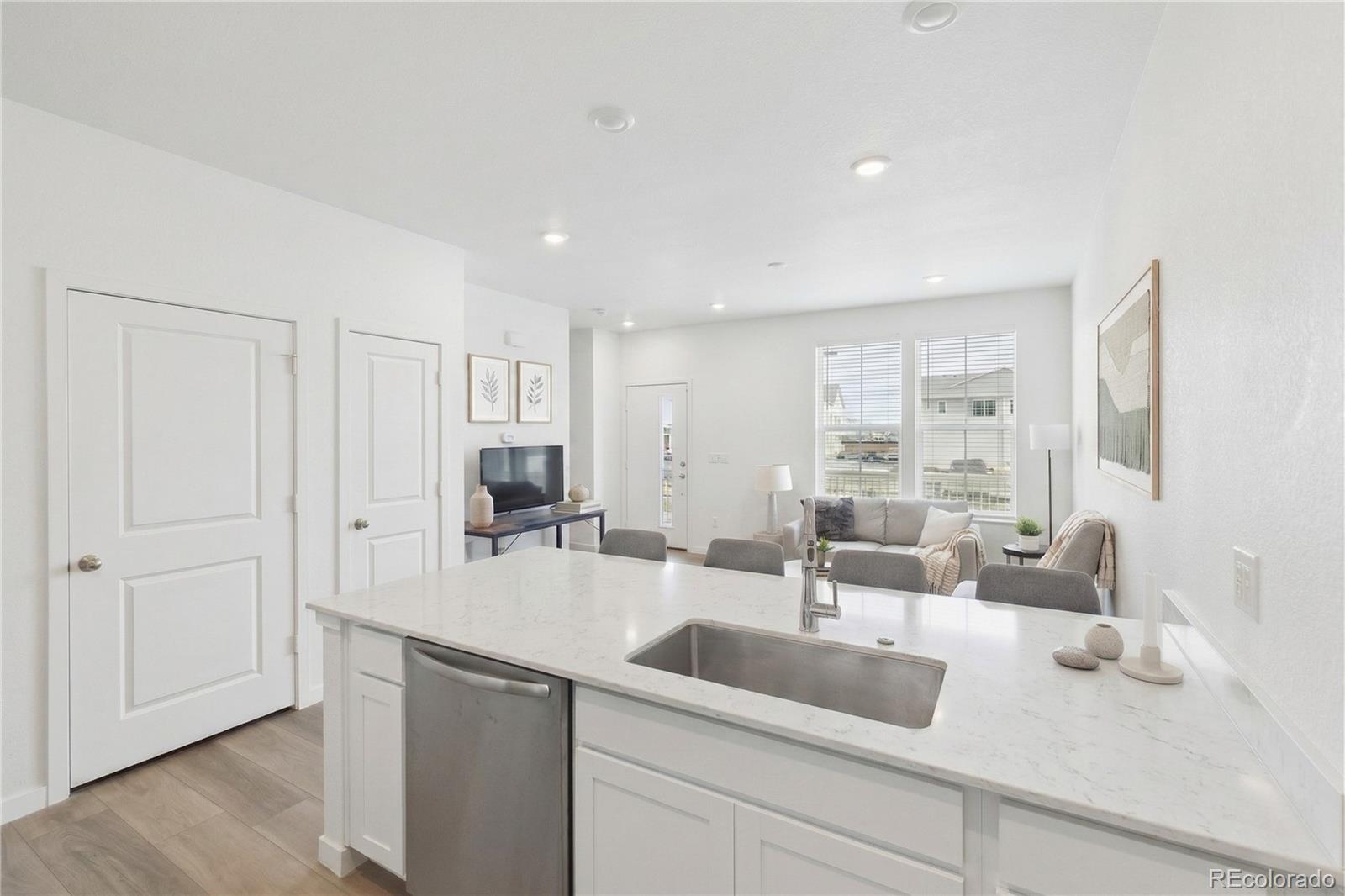 a kitchen with white cabinets and sink