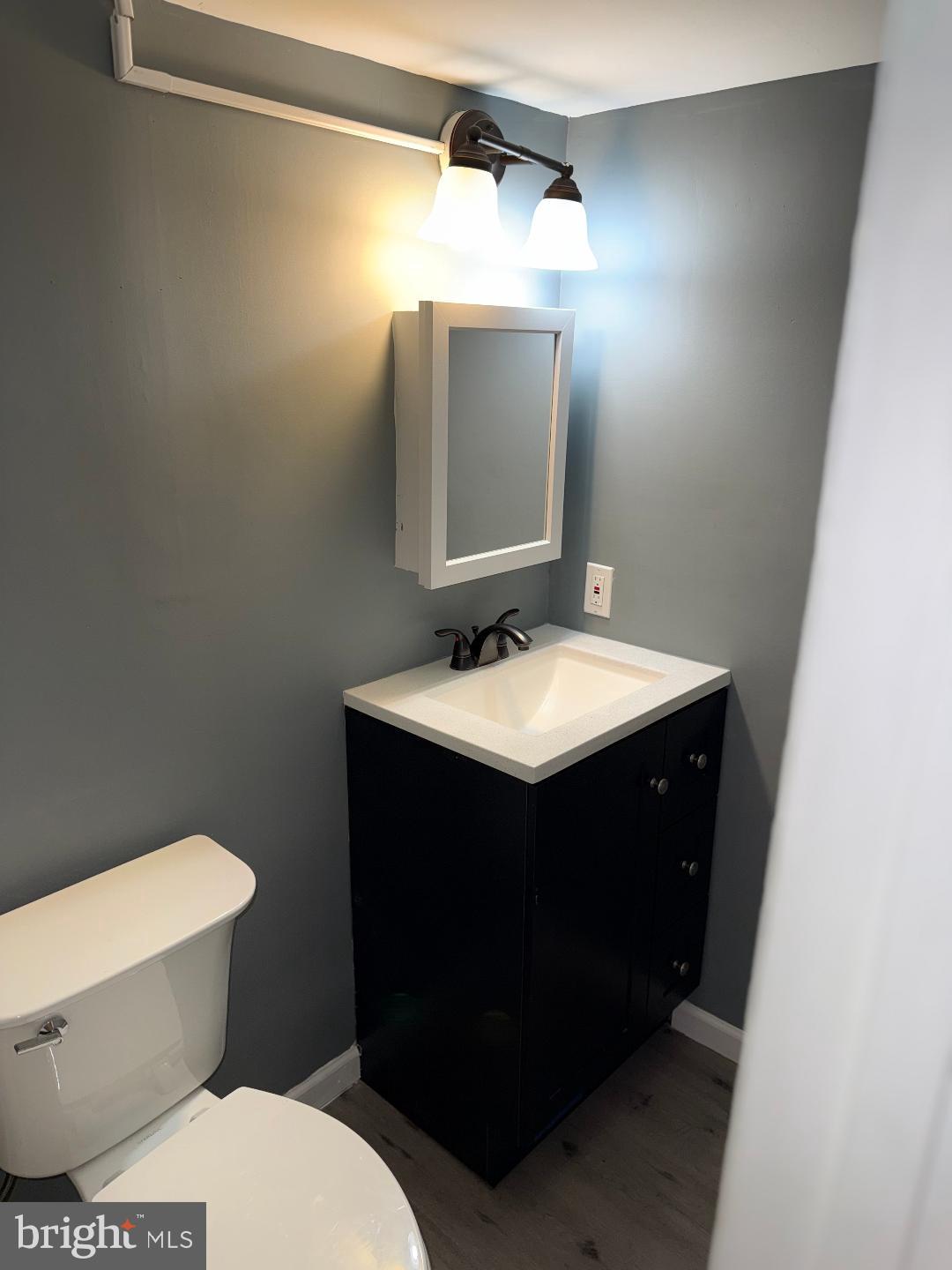 645 Queensgate Road Baltimore, MD 21229 - Photo 9 of 21 a bathroom with a sink vanity mirror and toilet