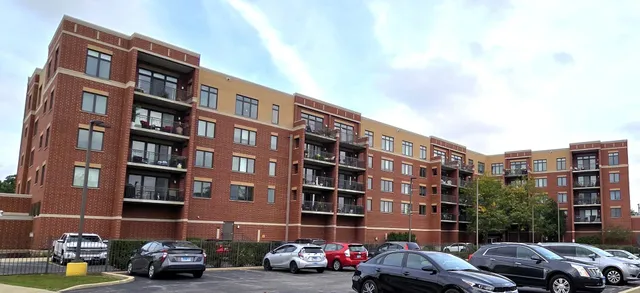 a front view of a building with lot of cars parked