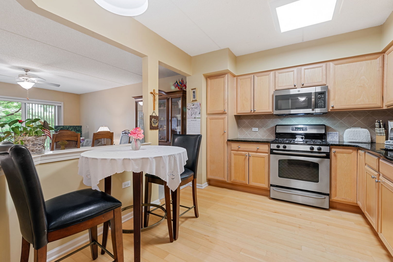 225 Main Street, Unit 201 Roselle, IL 60172 - Photo 7 of 21 a kitchen with stainless steel appliances a stove a sink cabinets and a dining table