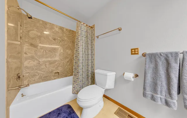 a bathroom with a toilet and a shower curtain