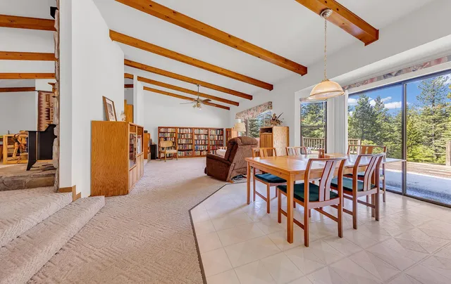 a dining room with furniture and a floor to ceiling window
