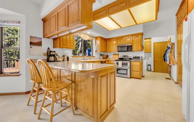 a kitchen with stainless steel appliances granite countertop a sink and a refrigerator