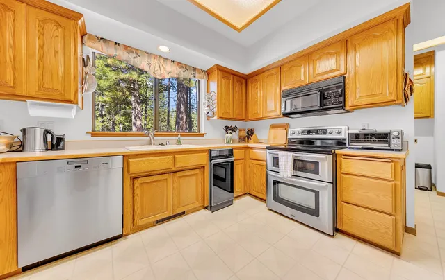 a kitchen with white cabinets sink and appliances