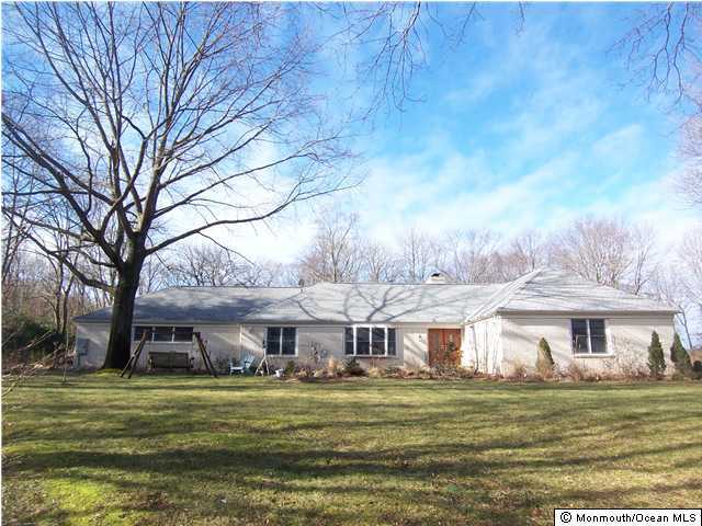8 Beaver Dam Road Colts Neck, NJ 07722 - Photo 1 of 3 a front view of a house with a garden