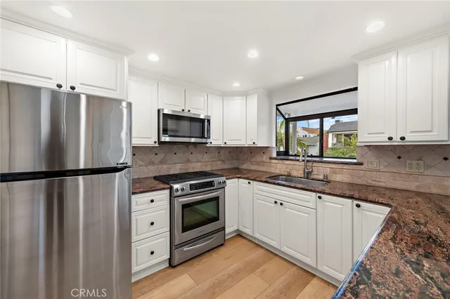 a kitchen with stainless steel appliances a refrigerator sink and microwave