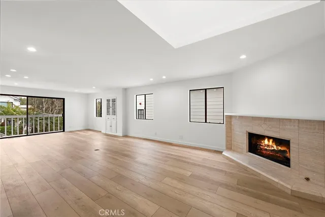 an empty room with windows and fireplace