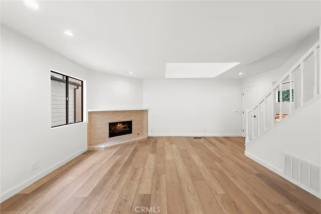 a view of a livingroom with wooden floor and a fireplace