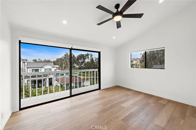 a view of a big room with wooden floor and windows