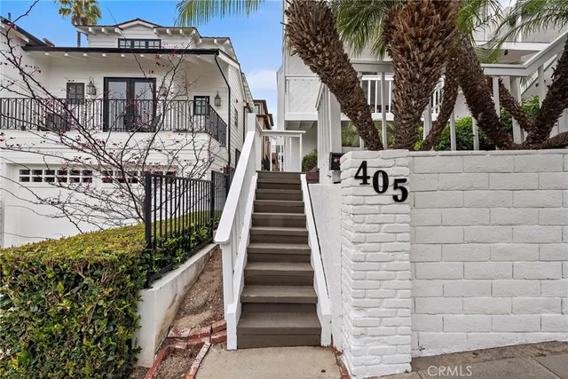 a view of a brick house with large windows and a small yard