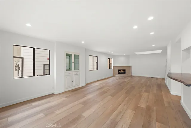 a view of empty room with kitchen and window