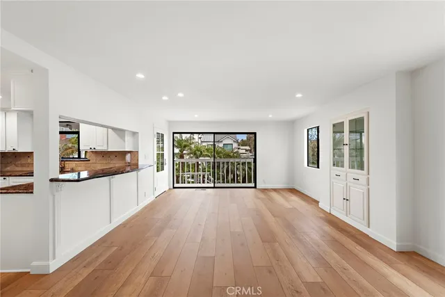 a open kitchen with white cabinets and wooden floor