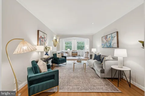 a living room with furniture a rug a window and a lamp