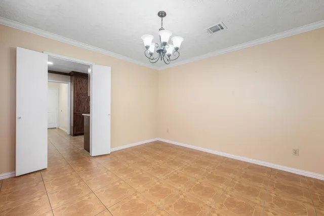 a view of an empty room with chandelier