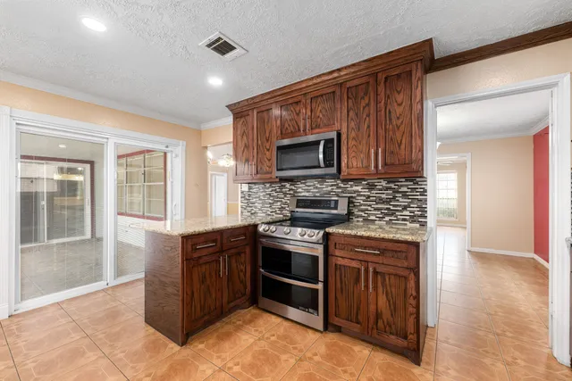 a kitchen with stainless steel appliances granite countertop a stove top oven sink and cabinets