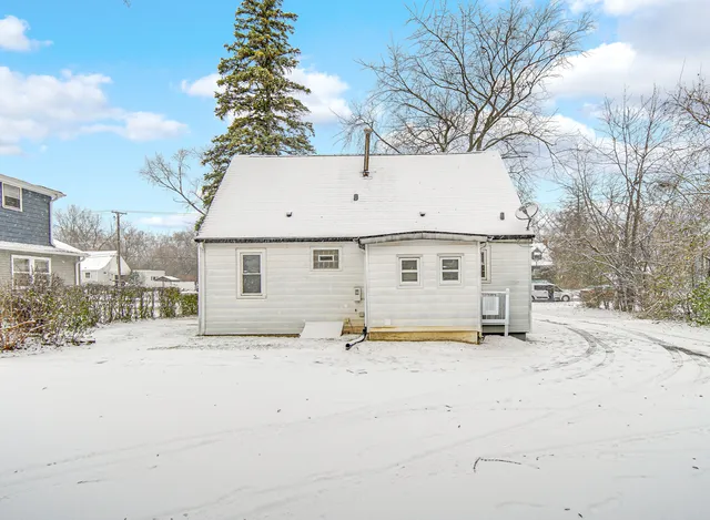 front view of house with a yard and trees