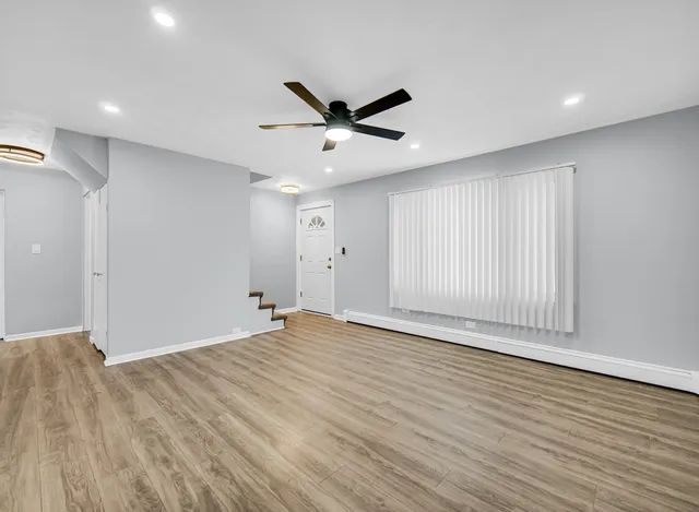 a view of an empty room with wooden floor