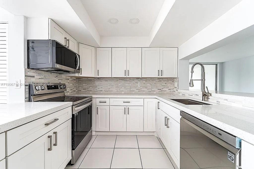 a kitchen with stainless steel appliances granite countertop a sink and a stove