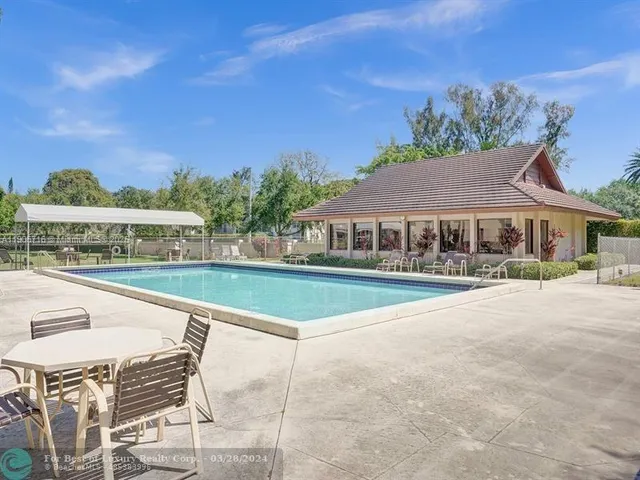 a view of house with outdoor space and swimming pool
