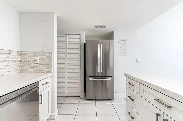a kitchen with a refrigerator sink and cabinets