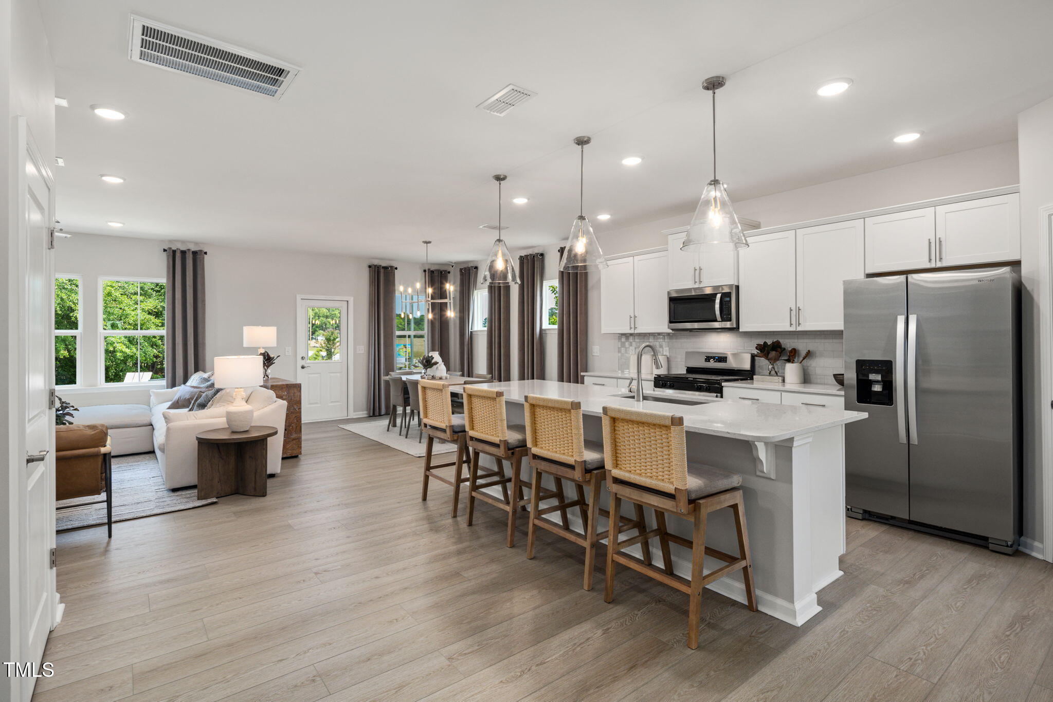 700 Ben Ledi Court Raleigh, NC 27603 - Photo 5 of 30 a large white kitchen with lots of counter space dining table and stainless steel appliances