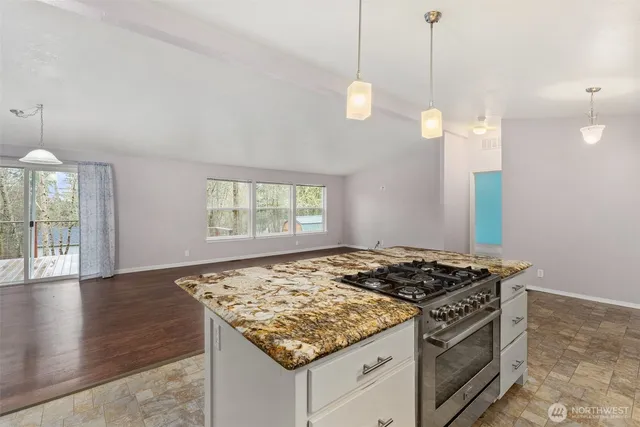 a kitchen that has a stove and a wooden floor