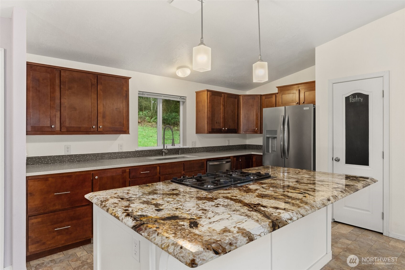 126 Burchett Road Onalaska, WA 98570 - Photo 9 of 36 a kitchen with kitchen island granite countertop a sink and refrigerator
