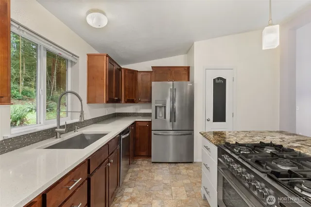 a kitchen with a stove a refrigerator and a sink