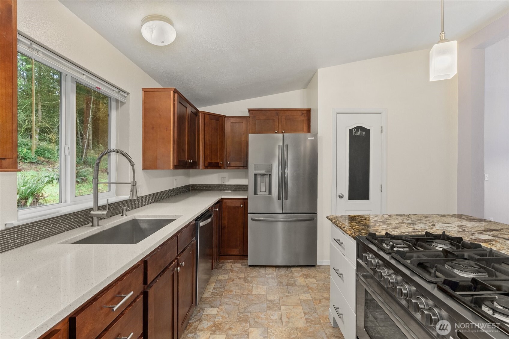 126 Burchett Road Onalaska, WA 98570 - Photo 10 of 36 a kitchen with a stove a refrigerator and a sink