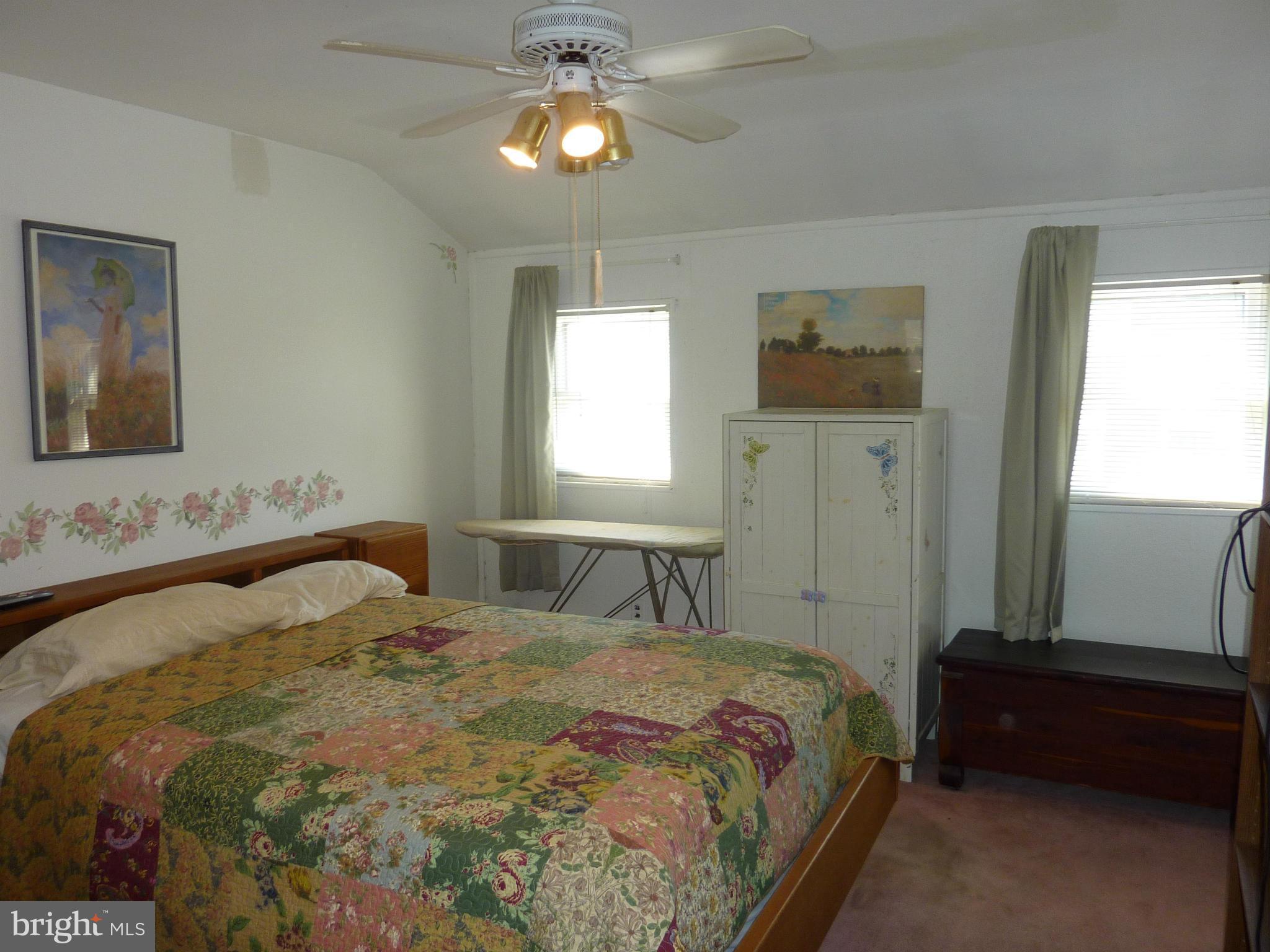 8019 Charlesmont Road Baltimore, MD 21222 - Photo 17 of 25 a bedroom with a bed and a chandelier