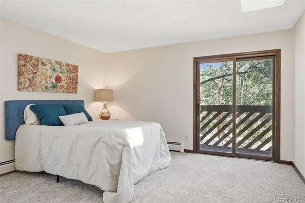 a spacious bedroom with a bed a mirror and windows