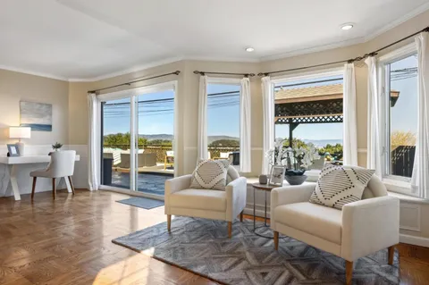a living room with fireplace furniture and a large window