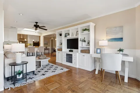 a living room with furniture a flat screen tv and kitchen view