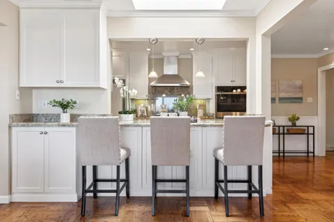 a kitchen with stainless steel appliances kitchen island granite countertop a kitchen island and chairs in it