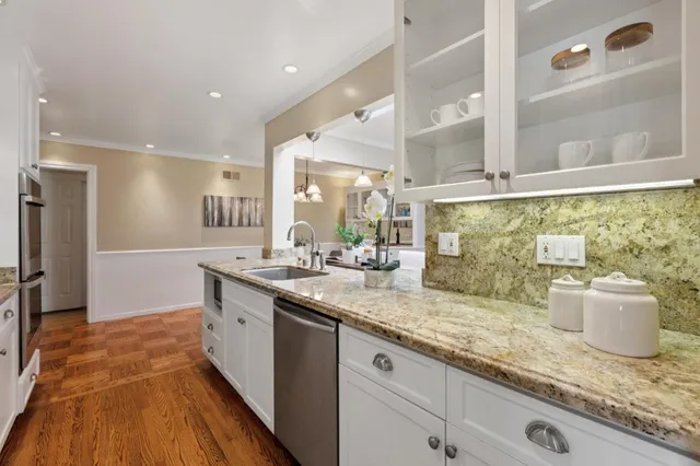 a large kitchen with stainless steel appliances granite countertop a lot of counter space and a sink