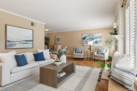 a living room with furniture and a painting on the wall