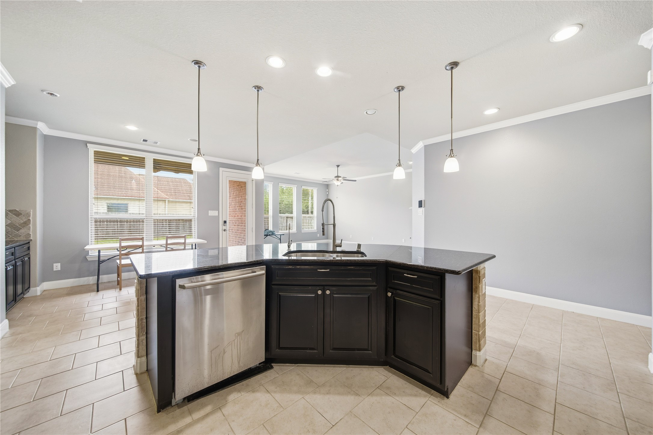 5303 Mesquite Willow Lane Rosharon, TX 77583 - Photo 14 of 32 Kitchen seamlessly connects to a bright dining area with large windows and a view of the covered patio.