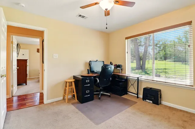 a view of a workspace with furniture and a window