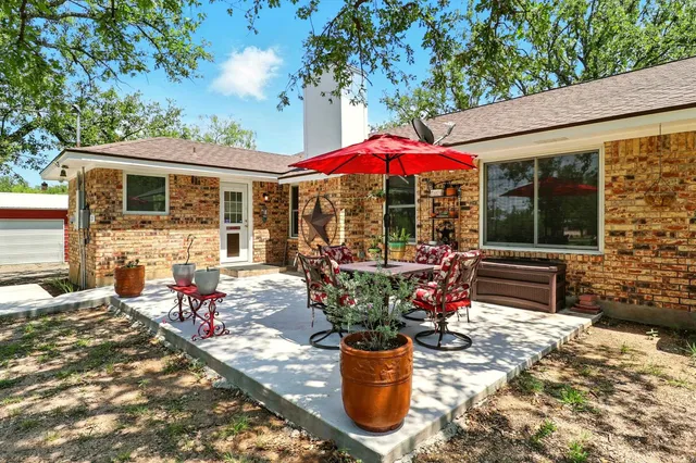 a view of a patio with table and chairs under an umbrella
