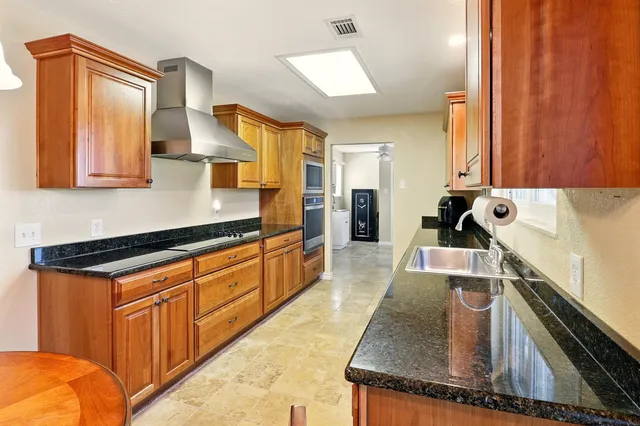 a kitchen with stainless steel appliances granite countertop a sink stove and cabinets
