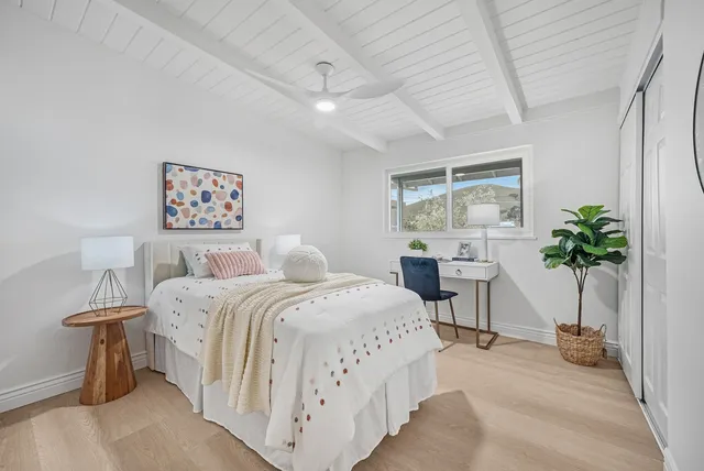 a bedroom with a large bed and a potted plant