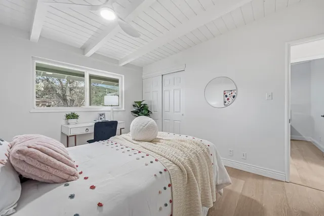 a bedroom with two beds and a large window